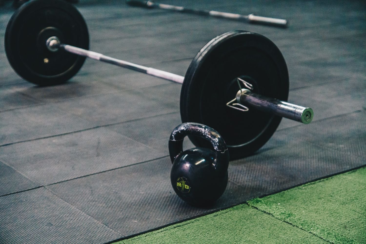 Barbell and kettlebell on a gym floor