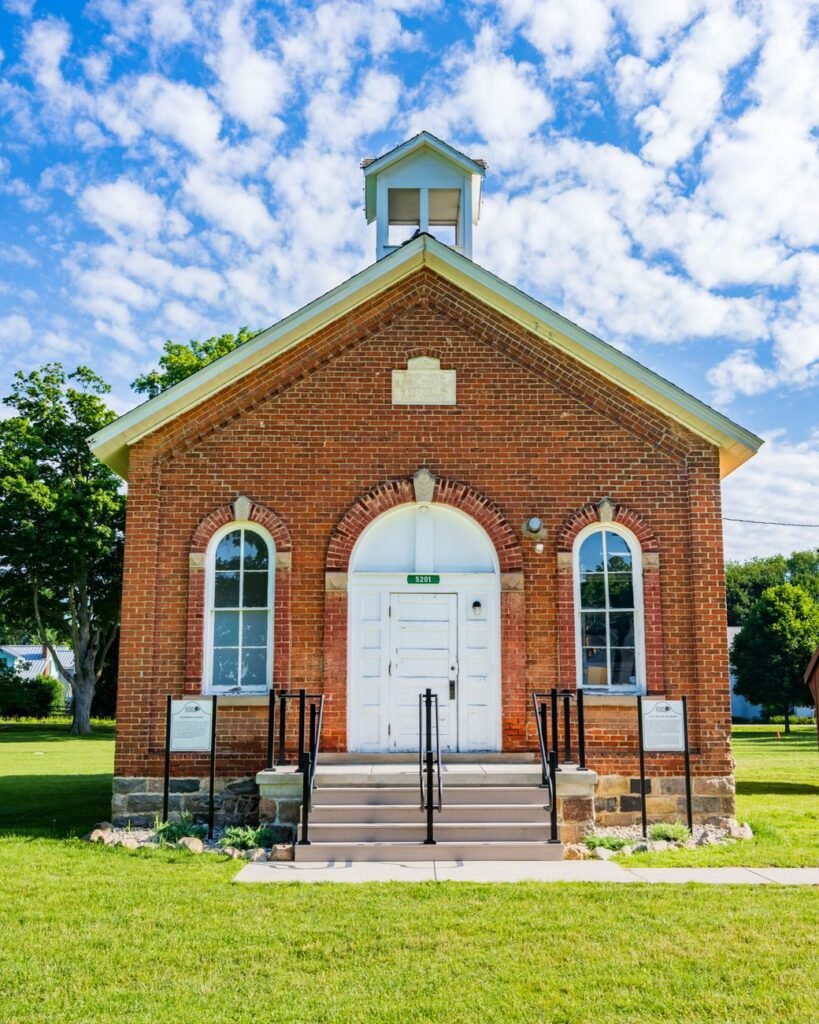 Historic brick building exterior under a clear sky, evocative of the small museum buildings found in towns like Algona Iowa