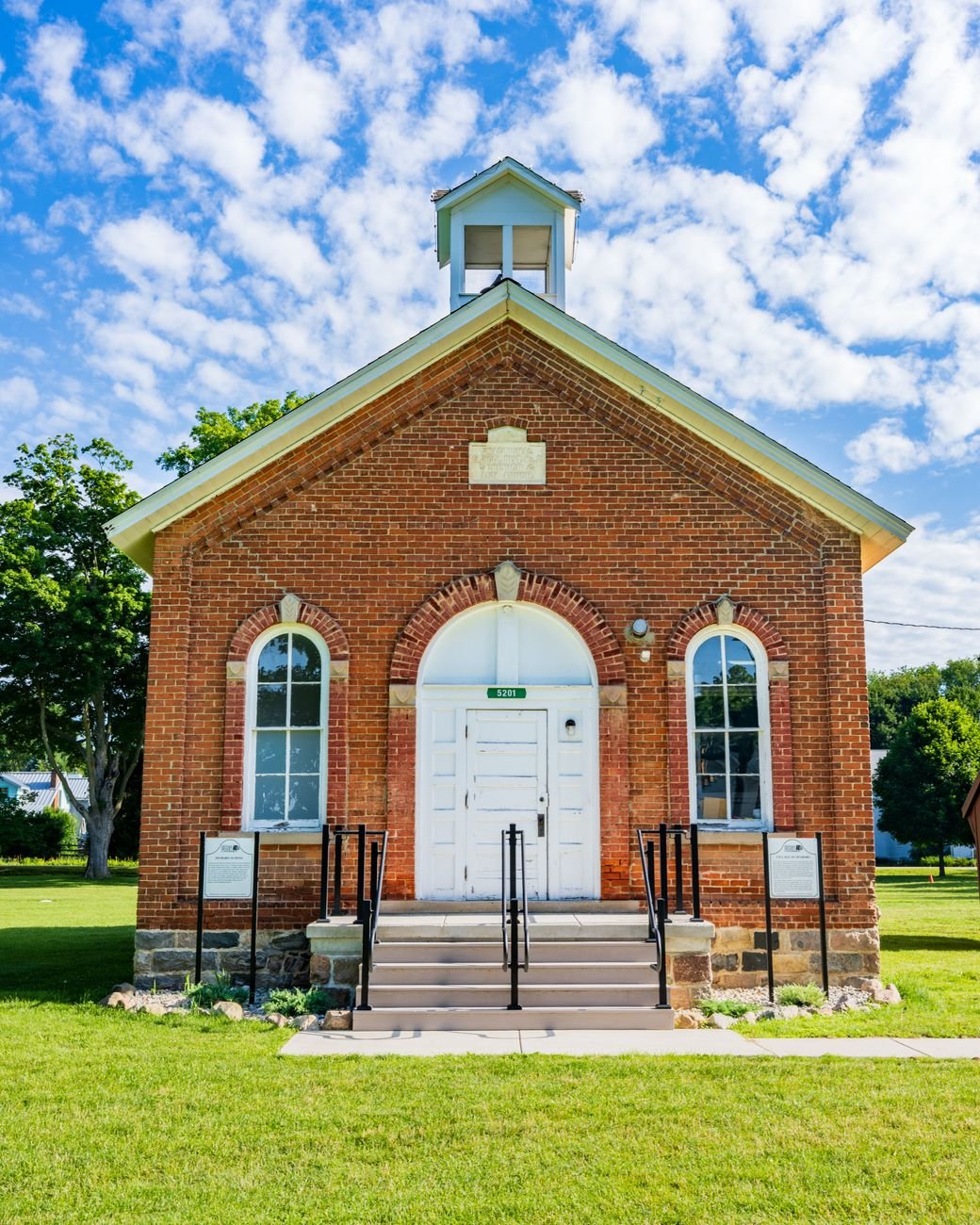 Historic brick building exterior under a clear sky, evocative of the small museum buildings found in towns like Algona Iowa