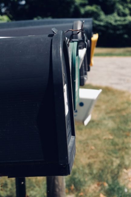 Row of curbside residential mailboxes on a small town street in Iowa