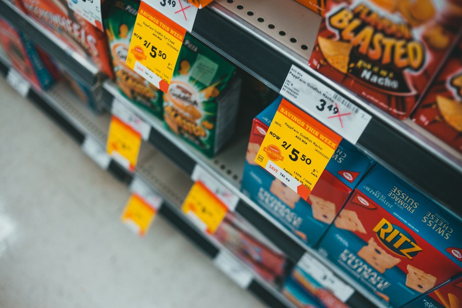 Supermarket aisle with discounted snacks and sale signage