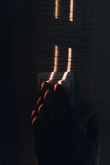 Hand flipping a light switch after moving into a new apartment