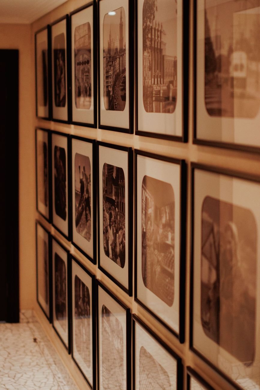 Sepia toned historical photographs displayed in ornate frames on a museum wall