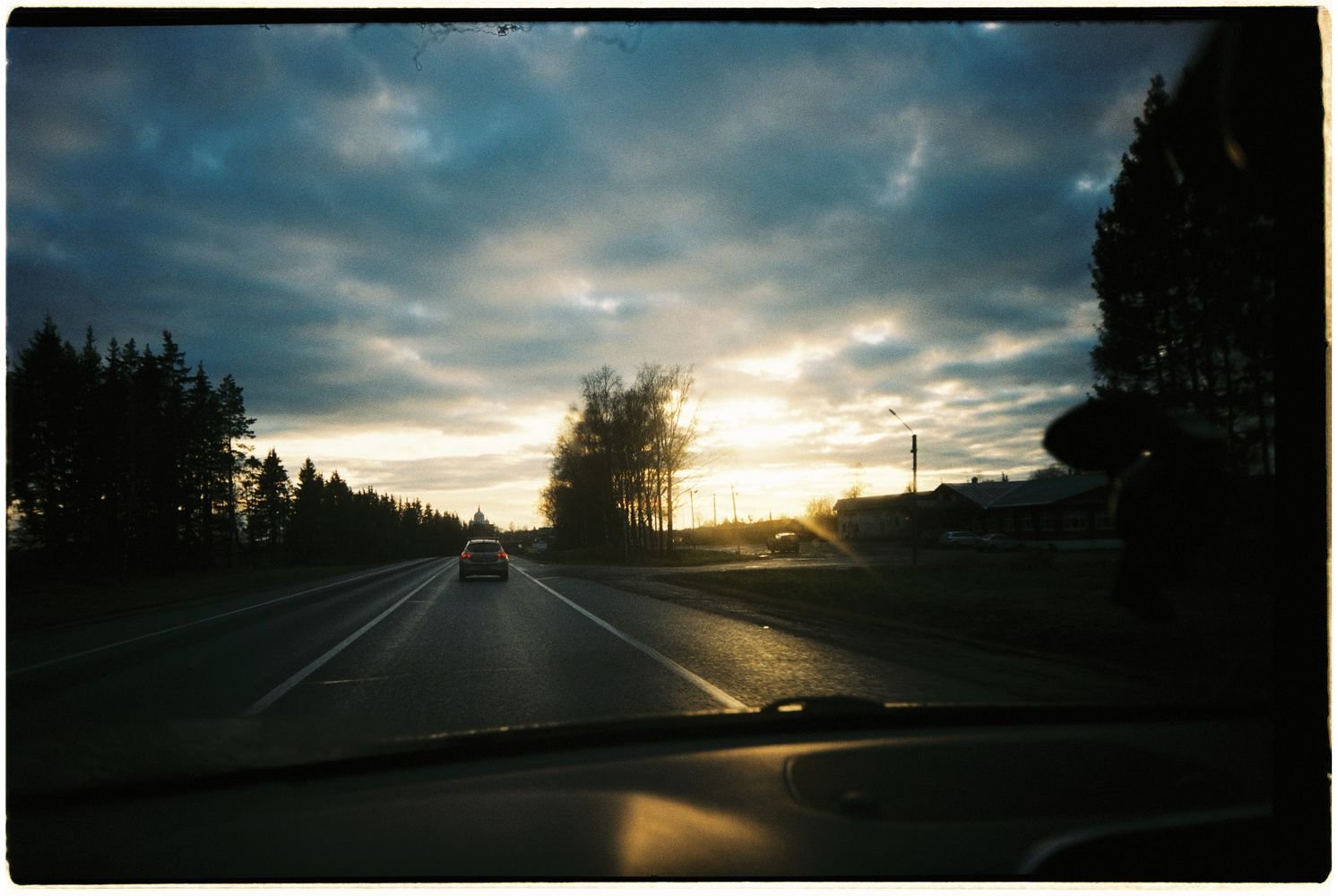 Car traveling on a scenic road at sunset