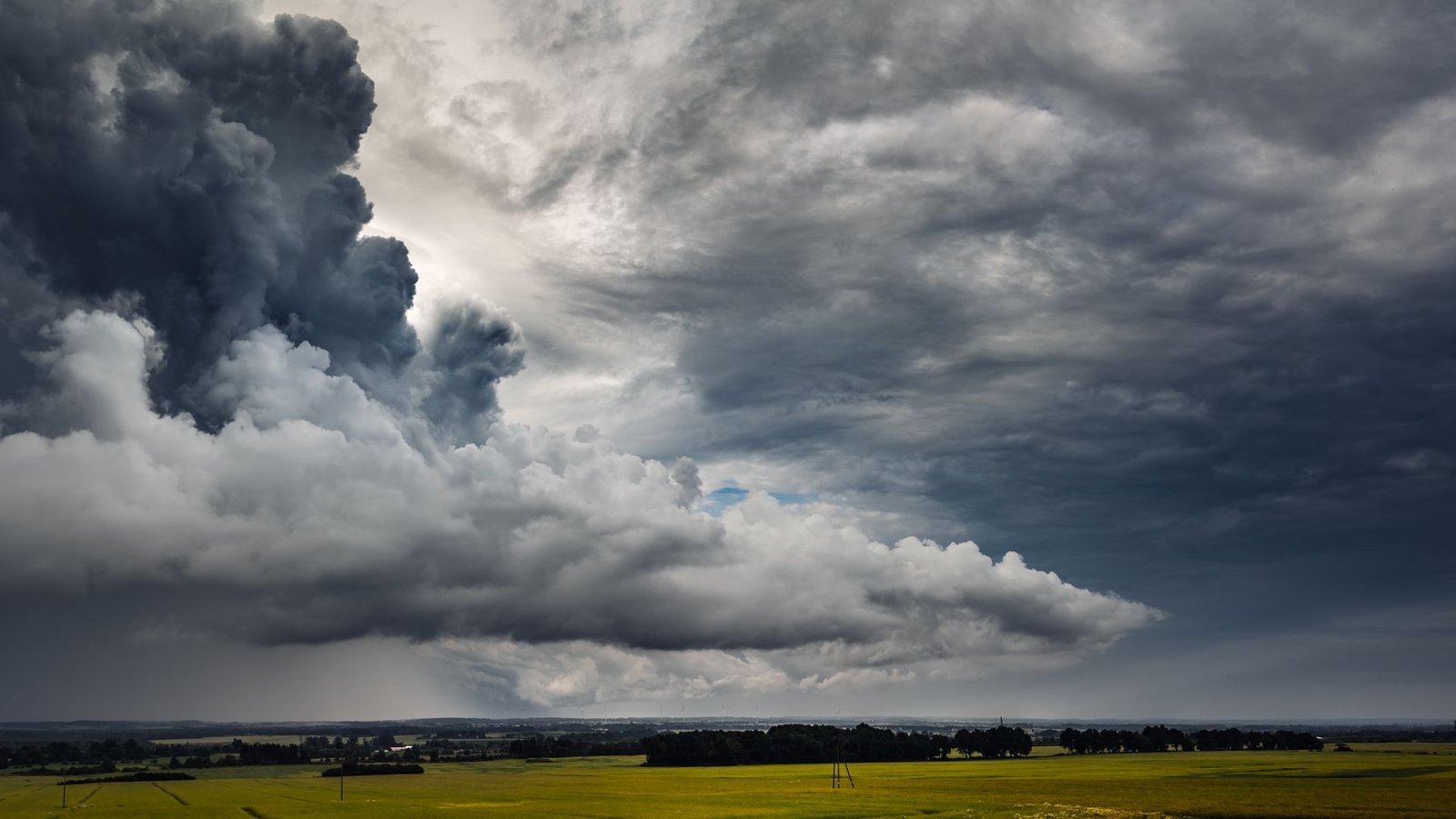 Dark storm clouds building over a green field